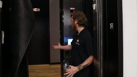 mover calling the elevator in a high-rise apartment lobby, face visible