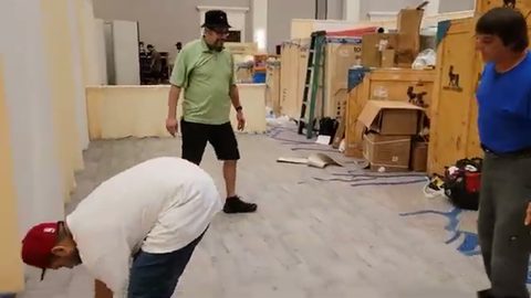 trade show crew working among large wooden exhibit crates, face visible